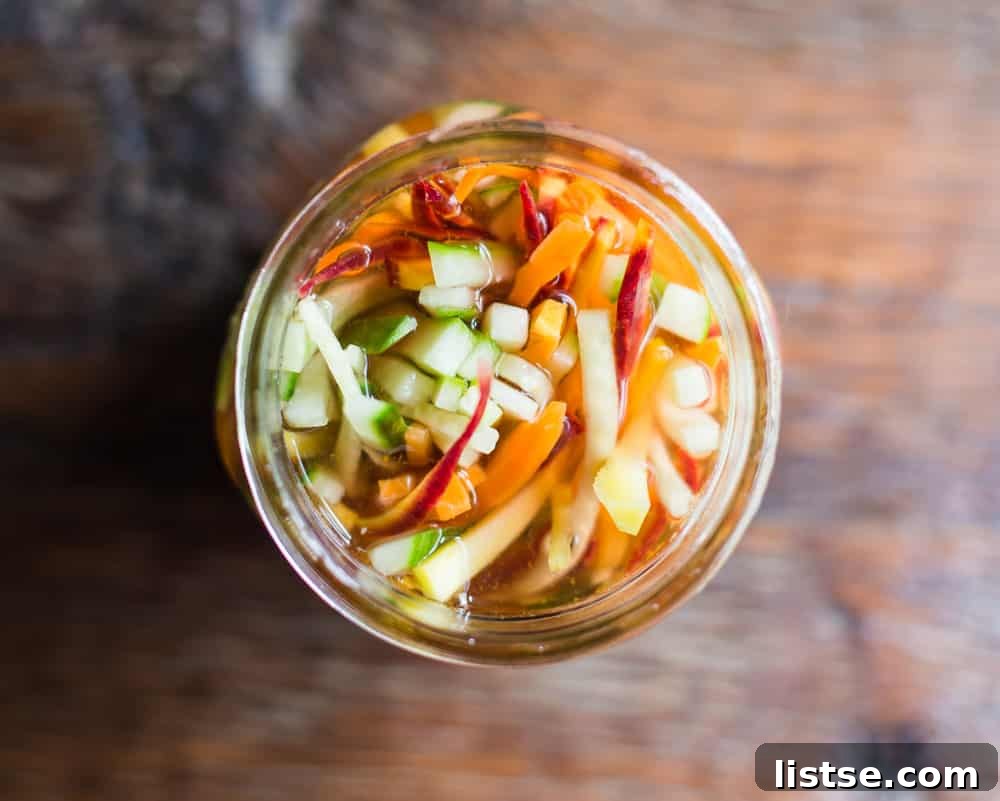 Freshly prepared pickled carrots and cucumber stored in a mason jar.