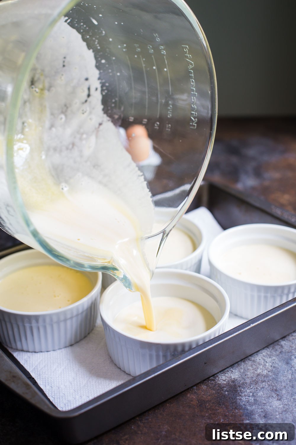 Dairy-Free Crème Brûlée mixture poured into ramekins in a baking dish.