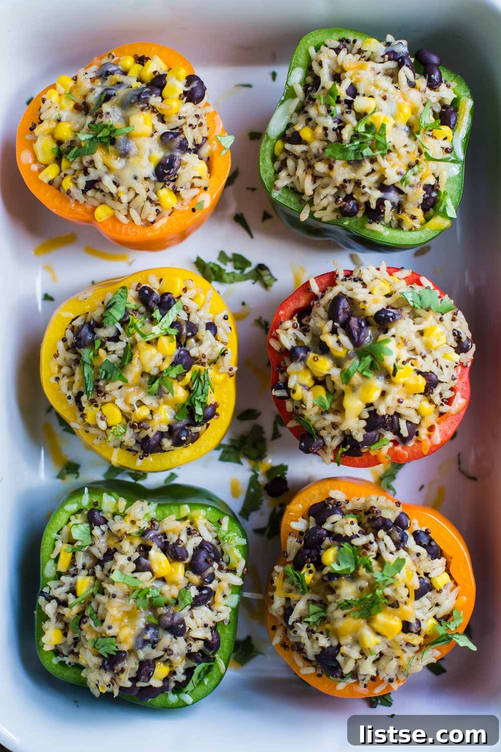 Loaded Burrito Stuffed Peppers 7 Vegan stuffed peppers topped with melted vegan cheese, ready for baking.