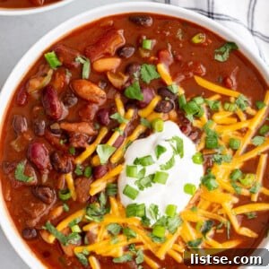 Vegan chili topped with plant-based sour cream and shredded dairy-free cheese.