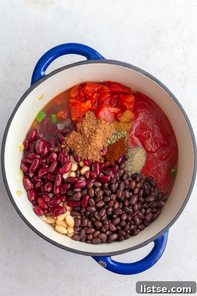 Ultimate Plant-Based Chili 6 Second step in making veggie chili: adding in the rinsed beans, robust spices, rich tomato sauce, diced tomatoes, and savory vegetable broth to the sautéed aromatics.