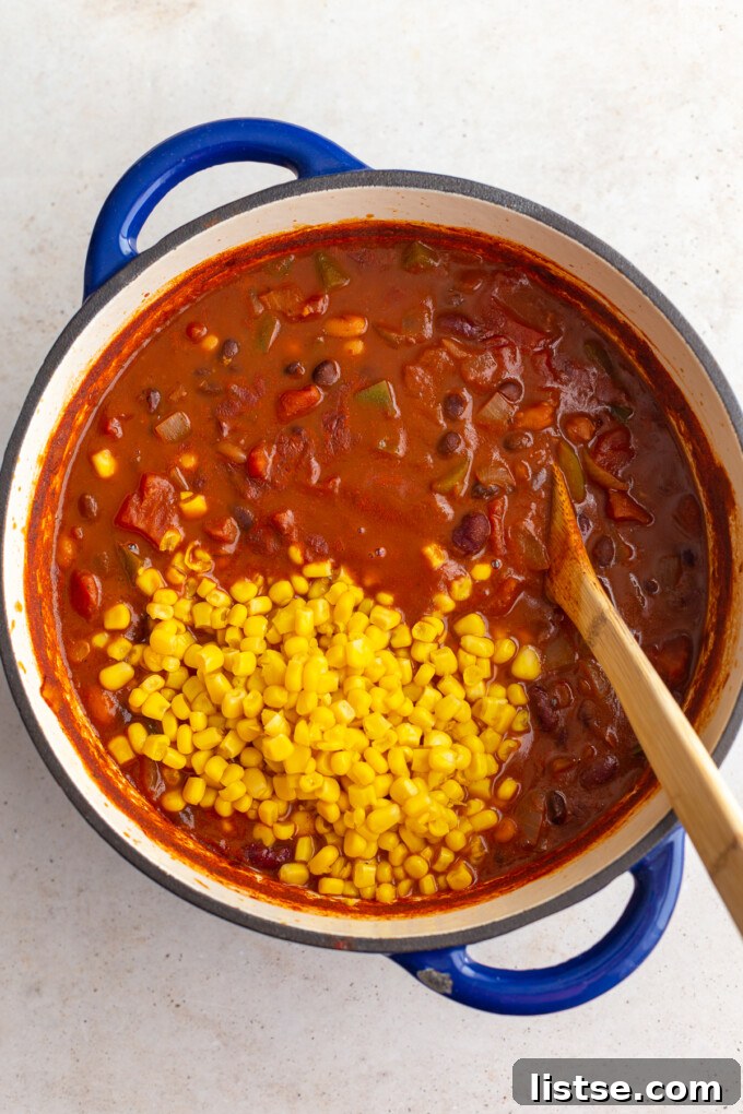 Ultimate Plant-Based Chili 7 Third step in making veggie chili: once the chili has simmered and flavors have melded, gently stir in the corn kernels to warm through just before serving.