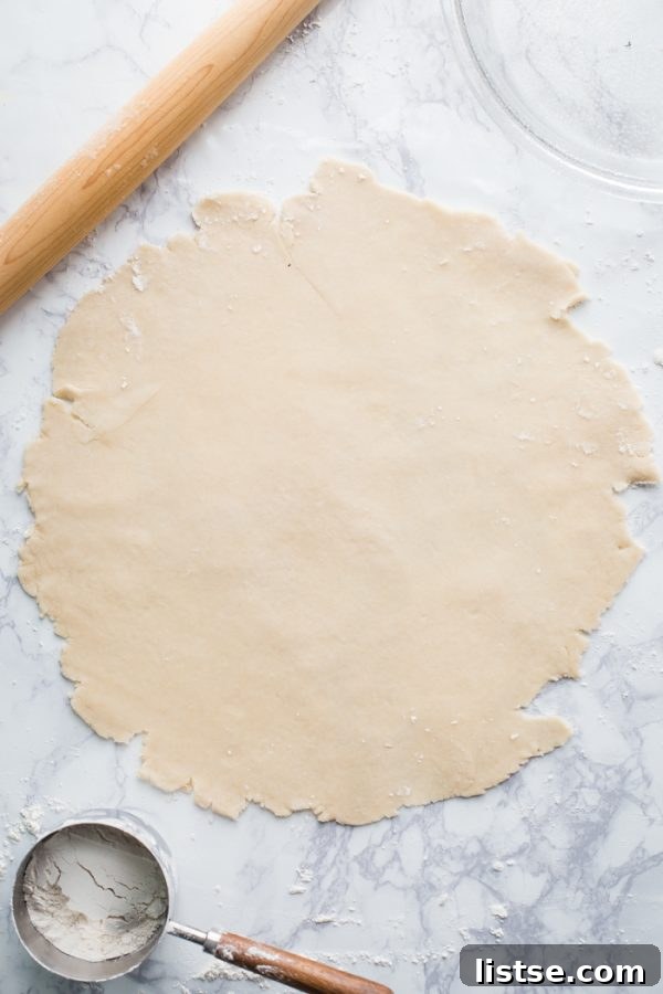 Two chilled vegan pie dough discs, tightly wrapped in plastic wrap, ready for rolling into pie crusts