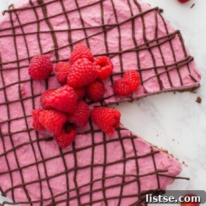 A perfectly portioned slice of Vegan Chocolate Raspberry Tart with a vibrant raspberry topping