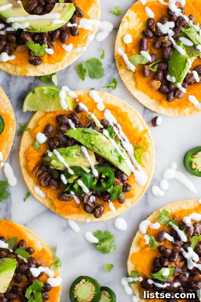 Vibrant Sweet Potato and Black Bean Tostadas 2 Two sweet potato and black bean tostadas on a marble board, garnished with fresh cilantro and lime