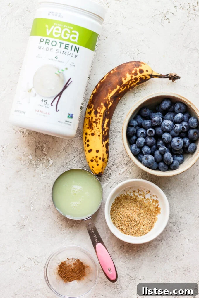 Power-Packed Banana Protein Pancakes 4 Collection of ingredients laid out on a table, including a ripe banana, egg whites, protein powder, and ground flaxseed, for making banana protein pancakes.