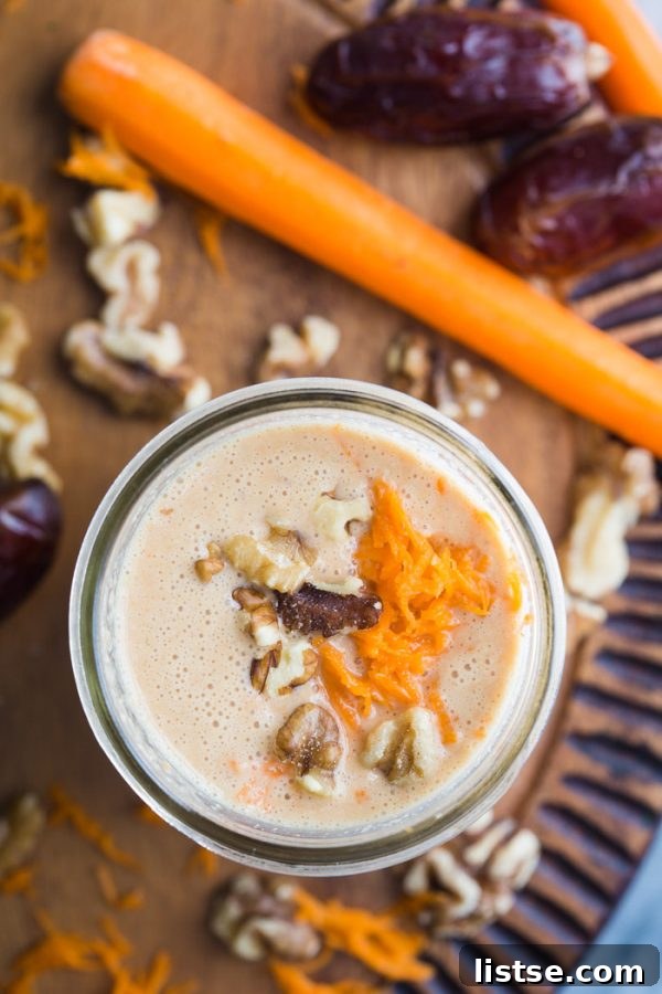 Delicious and healthy Carrot Cake Smoothie in a glass, topped with chopped walnuts.