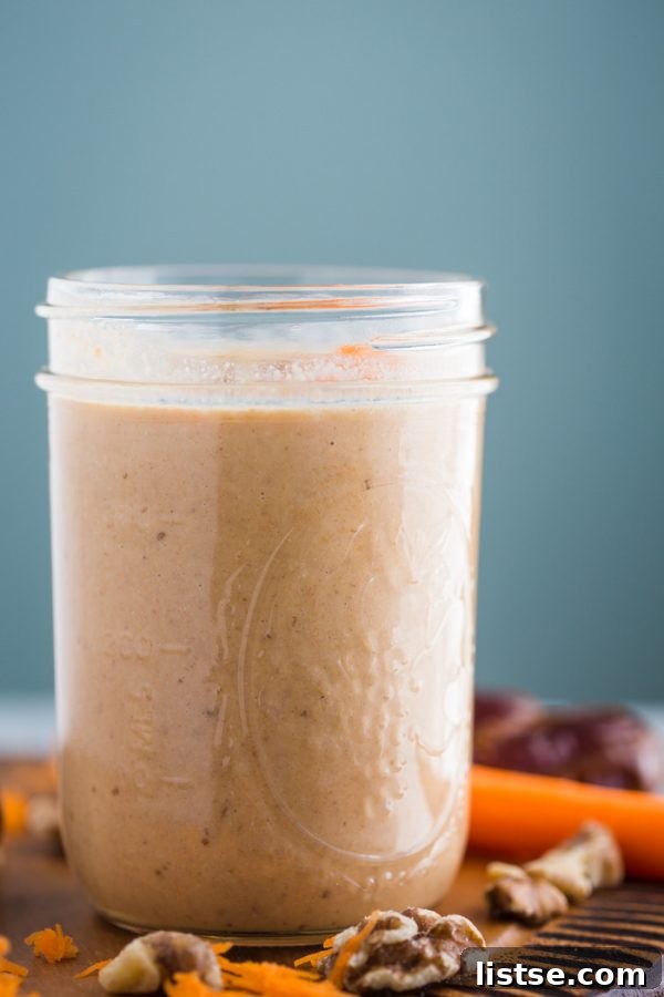 Close-up shot of a creamy Carrot Cake Smoothie with visible spices and grated carrot.