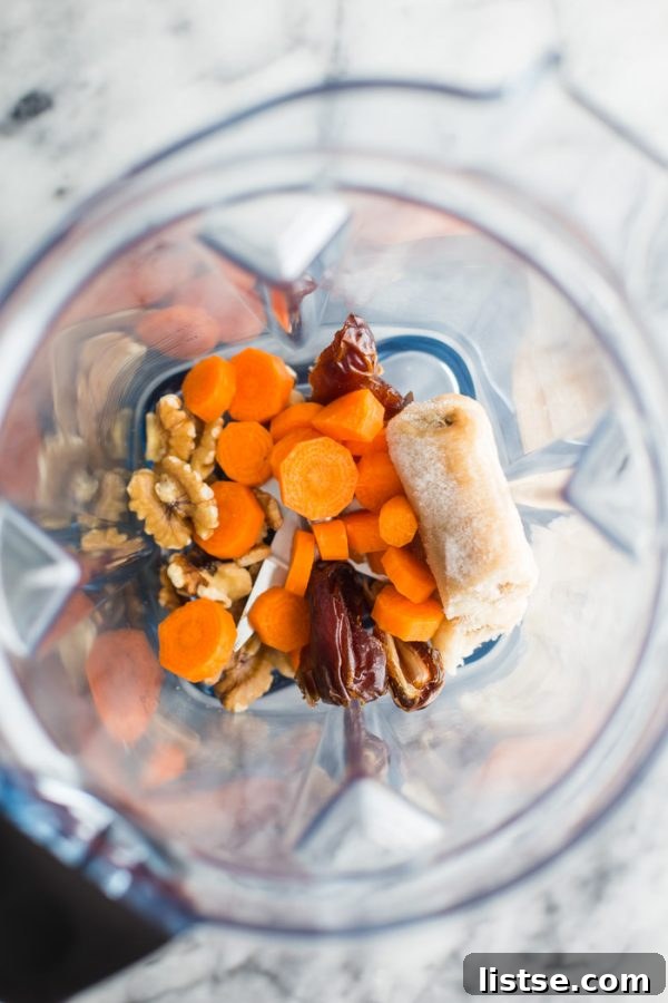 A vibrant orange Carrot Cake Smoothie with a straw, ready to be enjoyed.