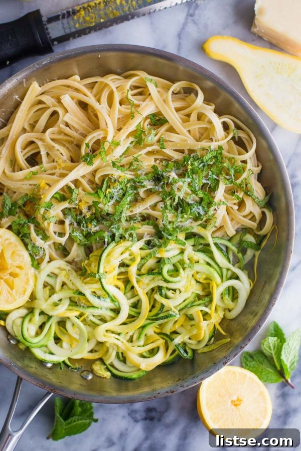Zoodle Linguine 4 Serving of Zucchini Linguine garnished with fresh parmesan cheese and mint, highlighting a delightful vegetarian pasta experience.