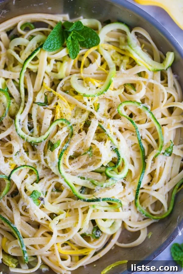 Zoodle Linguine 5 Overhead shot of Zucchini Linguine in a bowl, showcasing a mix of pasta and spiralized zucchini with fresh green herbs.