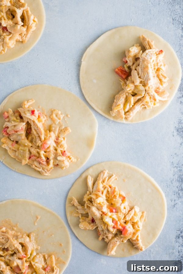 baked chicken empanadas arranged neatly on a baking sheet, fresh out of the oven
