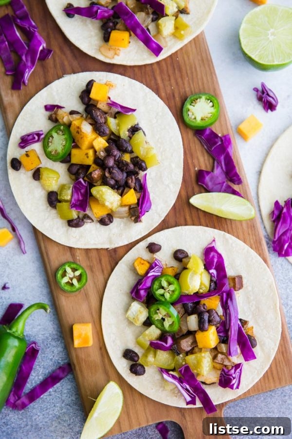 Close-up of Sheet Pan Squash Tacos ingredients roasting, highlighting butternut squash, black beans, and mushrooms.
