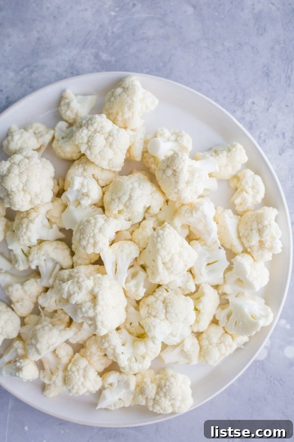 Platter of golden Sweet and Sour Cauliflower florets ready to be tossed in the flavorful sauce, an ideal vegan dish.