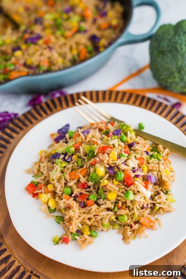 An overhead view of a bowl of Loaded Veggie Fried Rice, garnished with fresh green onions.