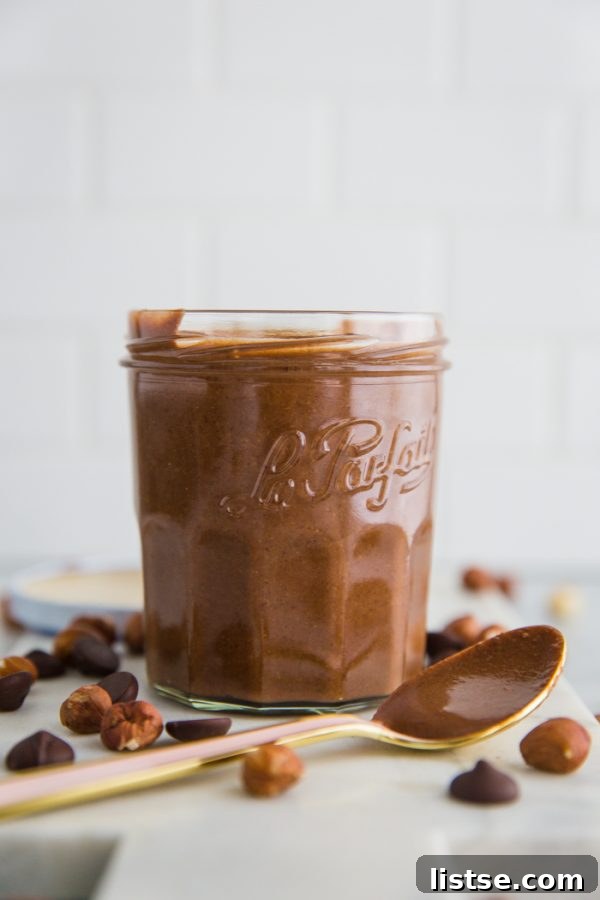 A close-up of freshly made homemade Nutella in a jar, showcasing its glossy surface and irresistible chocolatey goodness.