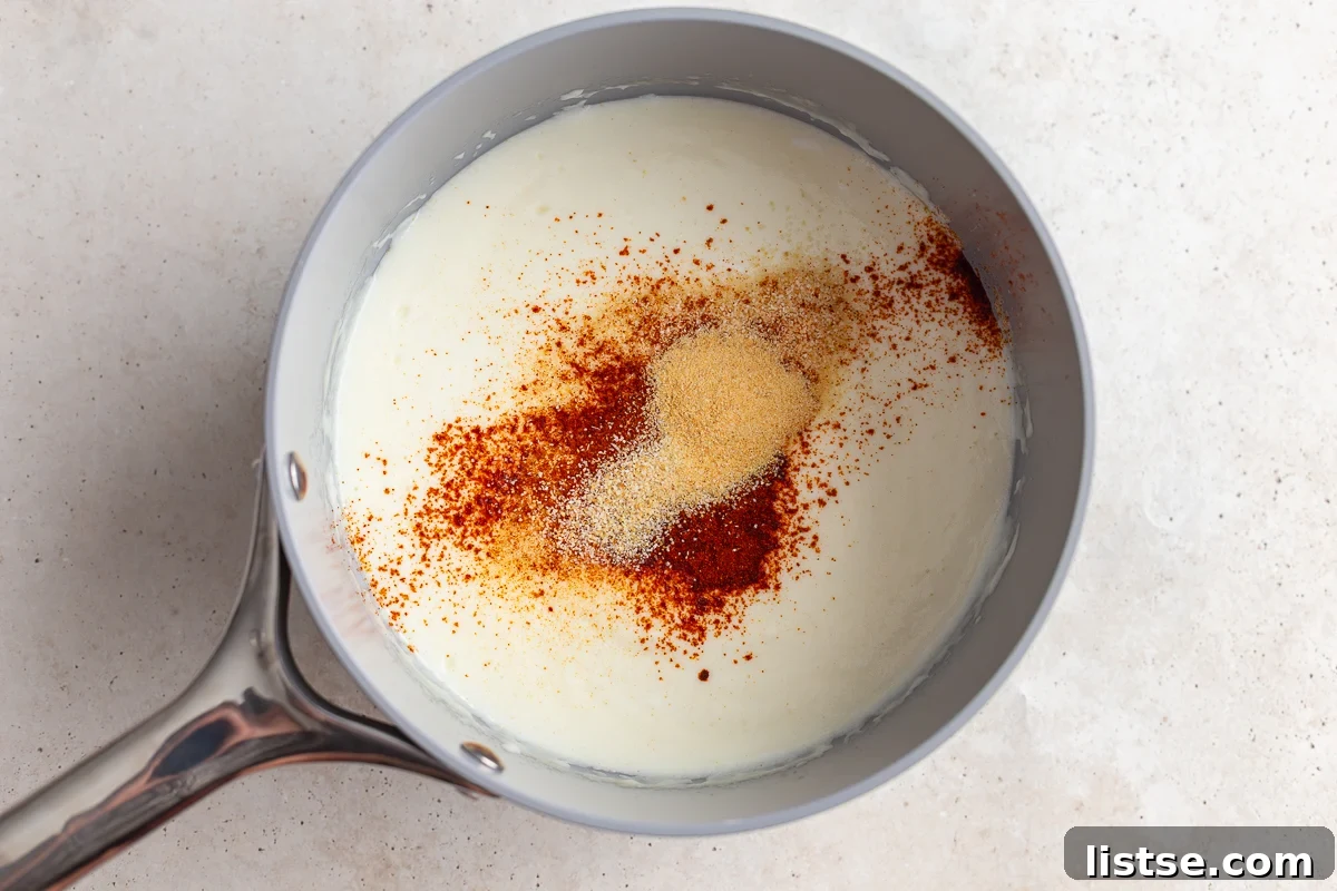 Making a creamy cheese sauce in a saucepan