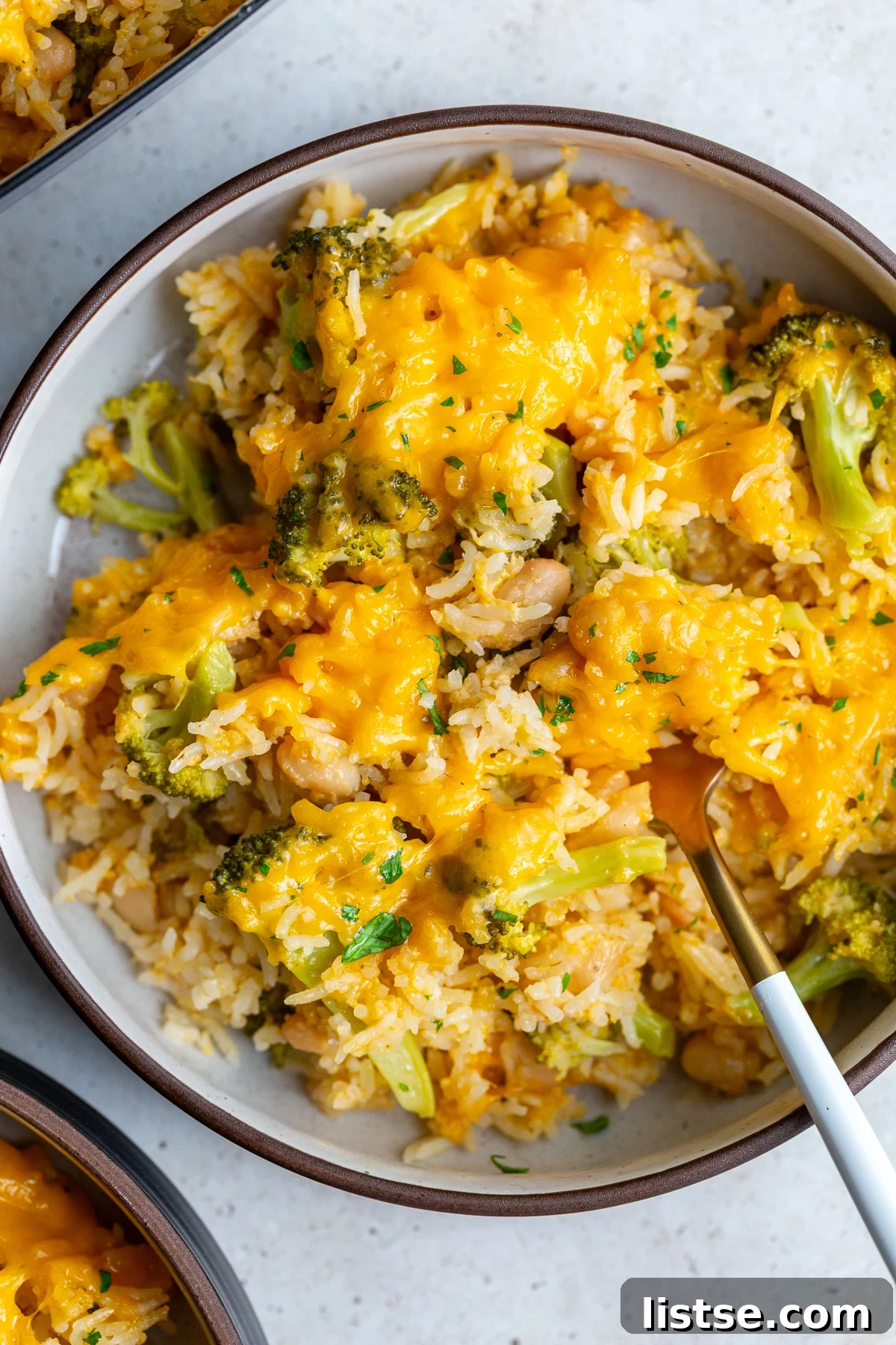 A serving of cheesy broccoli and rice casserole in a bowl, garnished
