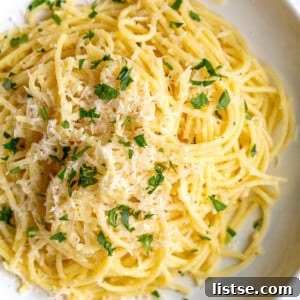 A bowl of glossy Garlic Butter Noodles, seasoned with fresh herbs and ready to be served.