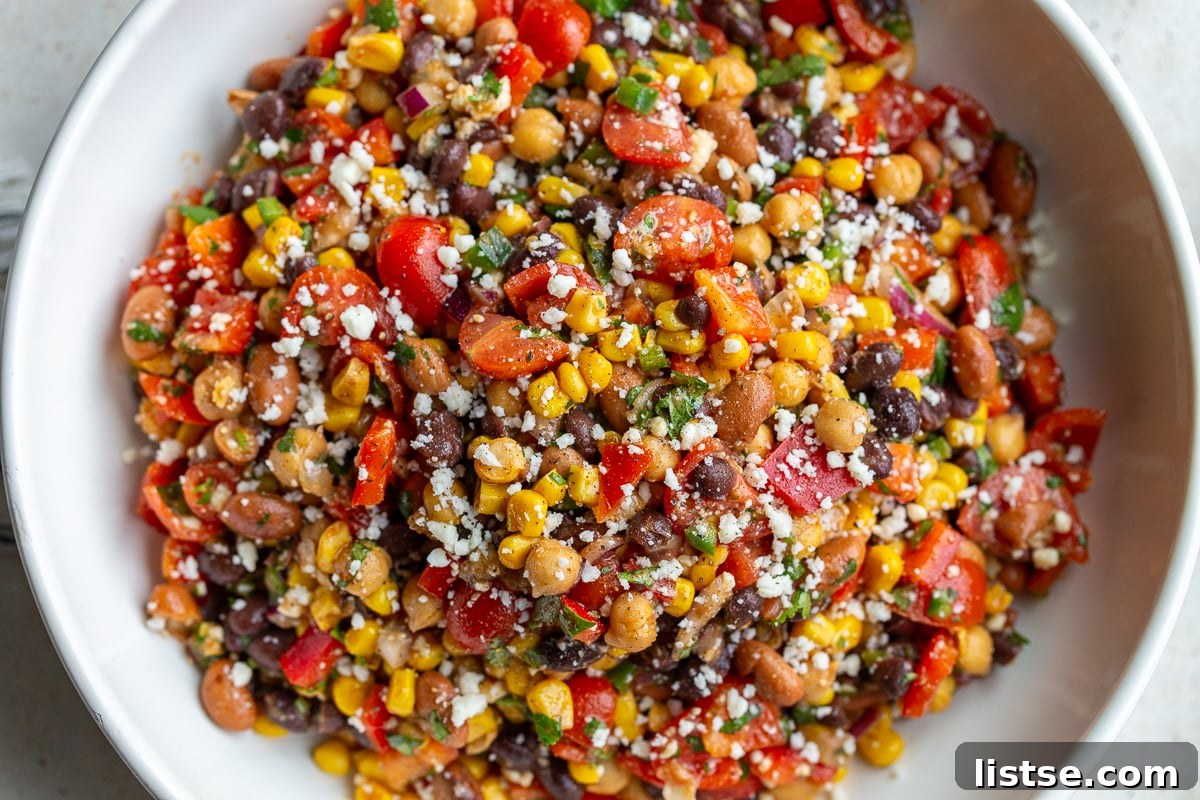 Large bowl of Southwest bean salad filled with three types of beans and lots of colorful veggies