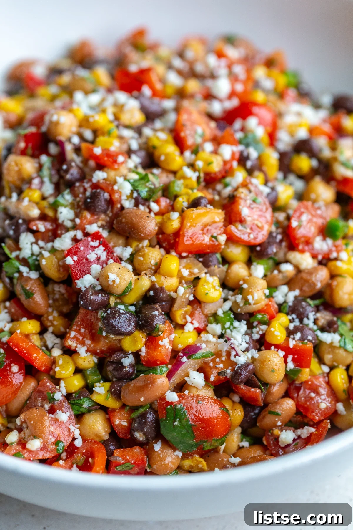 Large bowl of Southwest bean salad filled with 3 types of beans and lots of veggies, perfectly mixed