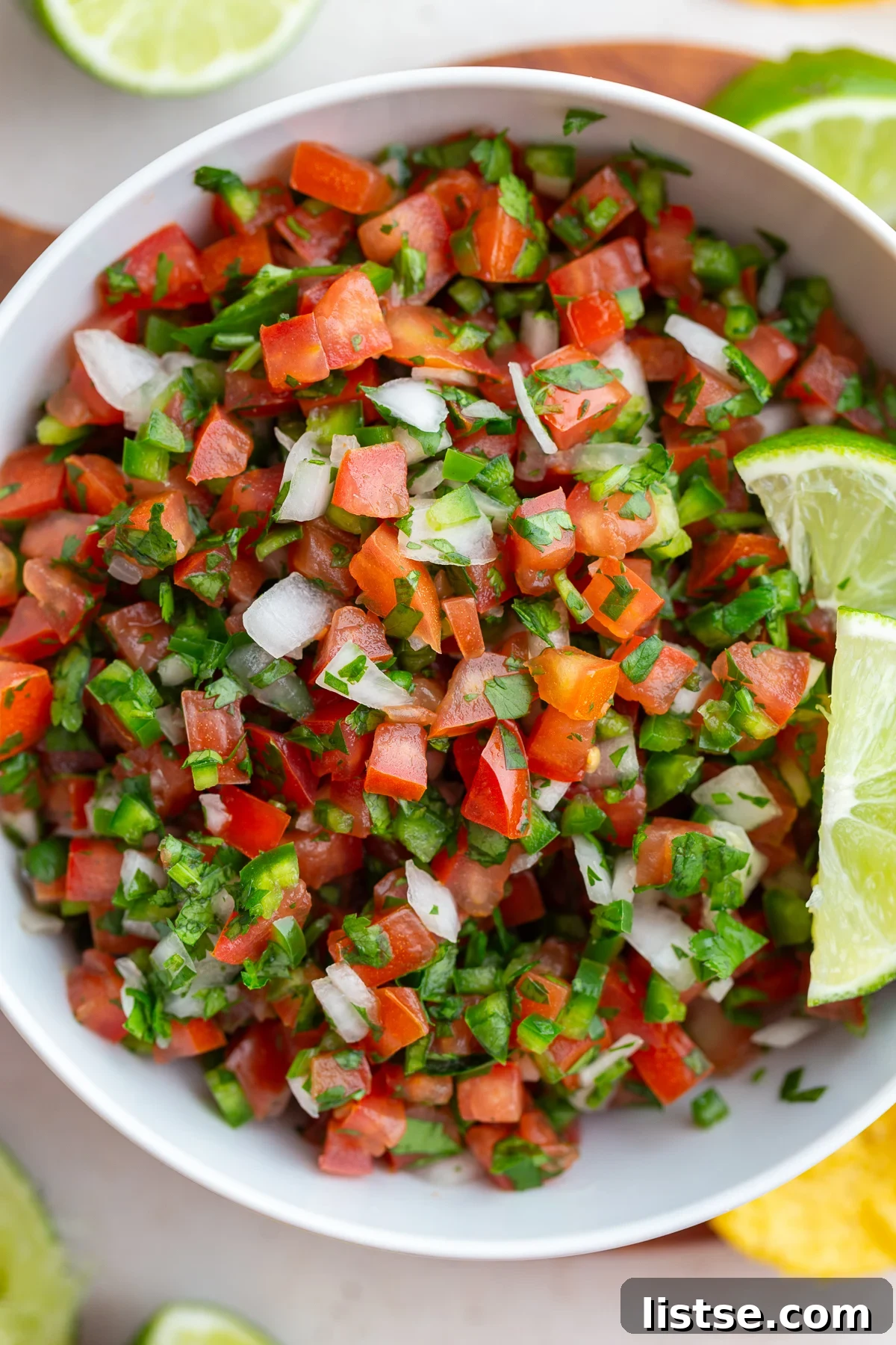 Crafting Perfect Pico de Gallo 10 pico de gallo in a white bowl with 2 limes on top