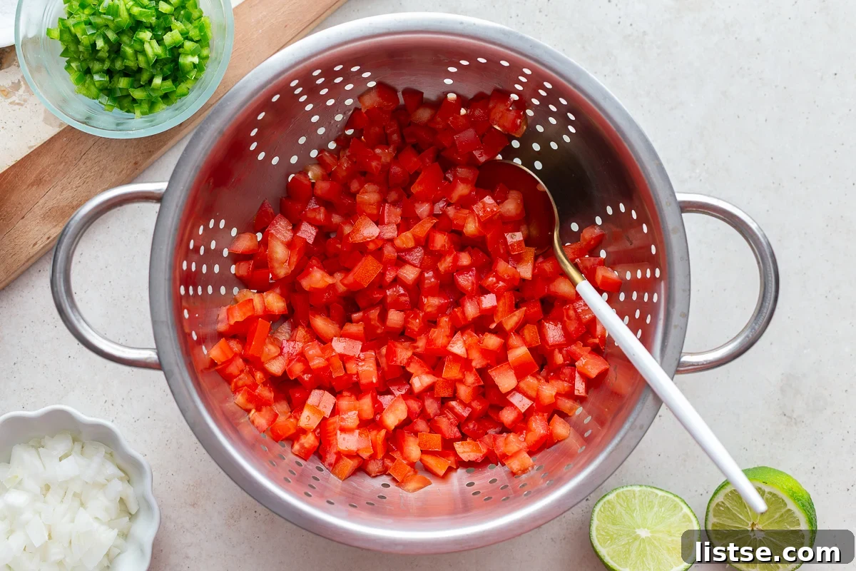 Crafting Perfect Pico de Gallo 6 diced tomatoes in a colander draining the excess liquid