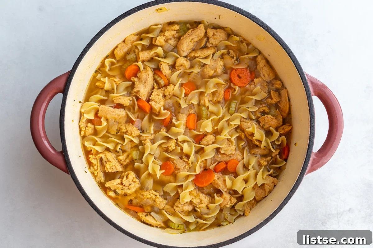 Quick and Cozy Vegan "Chicken" Noodle Soup 9 Vegetarian chicken noodle soup simmering in a large pot with noodles and soy curls.