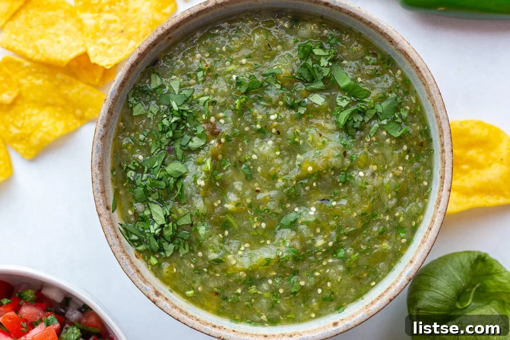A large bowl of homemade Roasted Salsa Verde, showcasing its vibrant green color and chunky texture, ready for dipping.