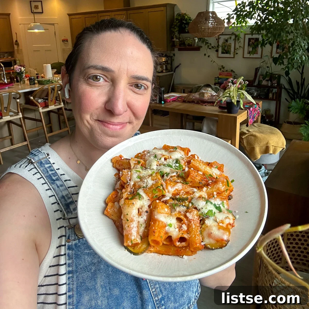 Balanced Meal Plan 38 2 Smiling woman holding a dish of pasta bake, promoting the weekly meal plan