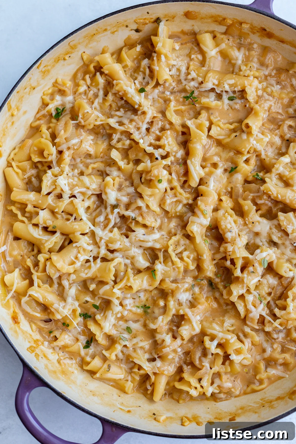 French onion soup pasta in a large skillet, garnished with fresh thyme