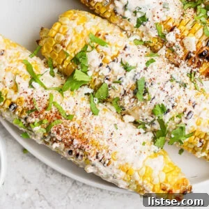 Delicious Mexican street corn on the cob, garnished with fresh cilantro and cotija cheese.