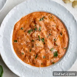 Vodka sauce butter beans on a white bowl topped with basil and parmesan cheese