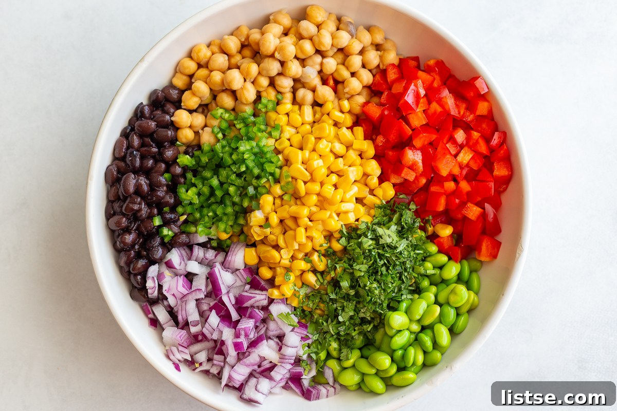 All the chopped vegetables and beans for the salad combined in a large mixing bowl before adding the dressing.