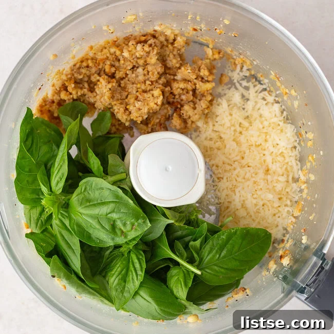 how to make pesto step 2: food processor that has processed pinenutes in it along with fresh basil and Parmesan cheese