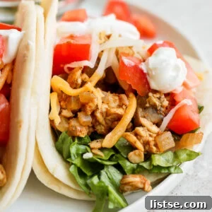 tempeh tacos topped with tomato, cheese, and sour cream