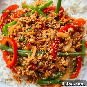 ground tofu stir fry with red bell pepper and green beans on a bed of white rice