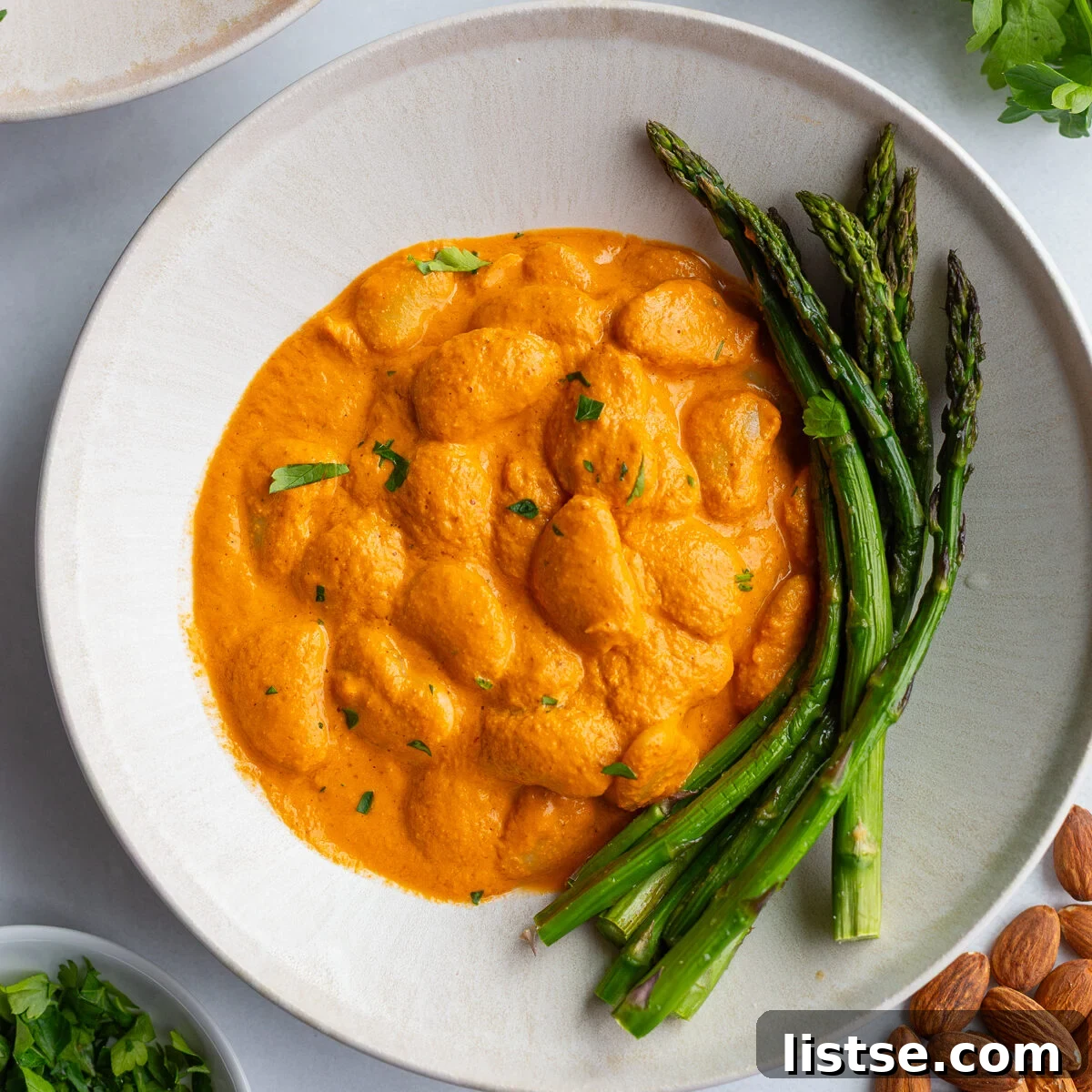 romesco butterbeans in a bowl with asparagus