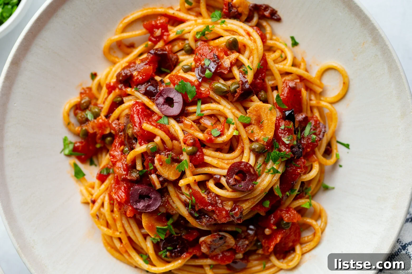Classic Pasta Puttanesca Recipe with Anchovies and Olives 2 pasta alla puttanesca on a large plate