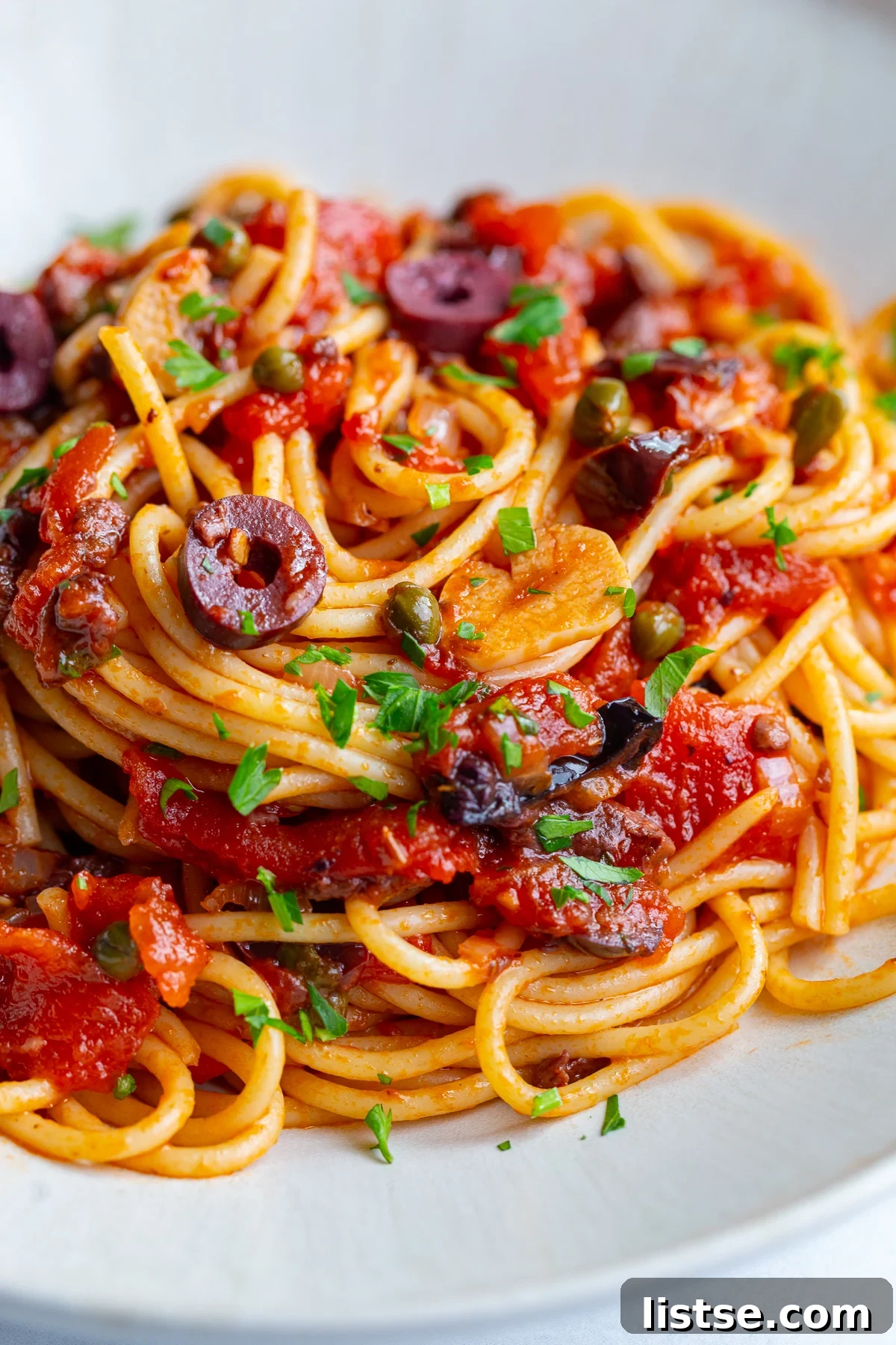 Classic Pasta Puttanesca Recipe with Anchovies and Olives 5 pasta alla puttanesca on a large plate