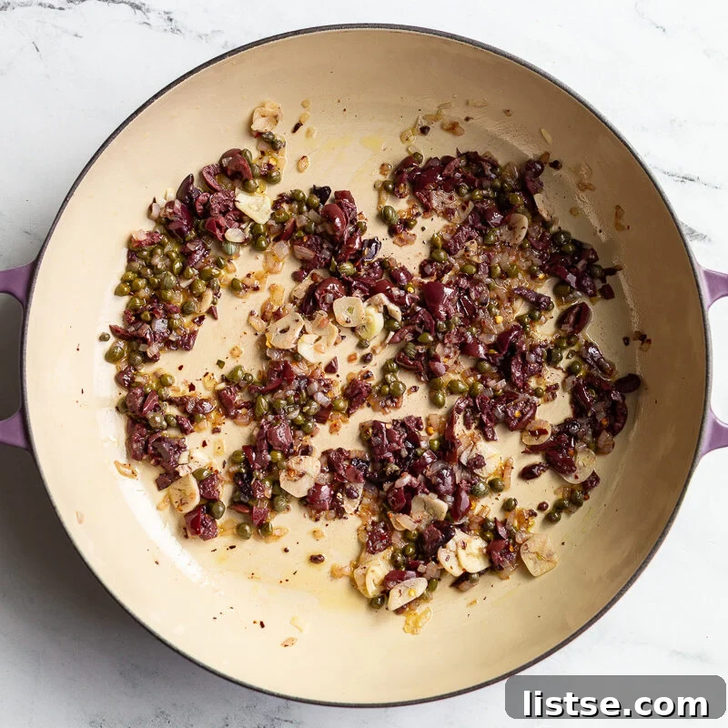 Classic Pasta Puttanesca Recipe with Anchovies and Olives 6 olives and capers sauteed in a skillet
