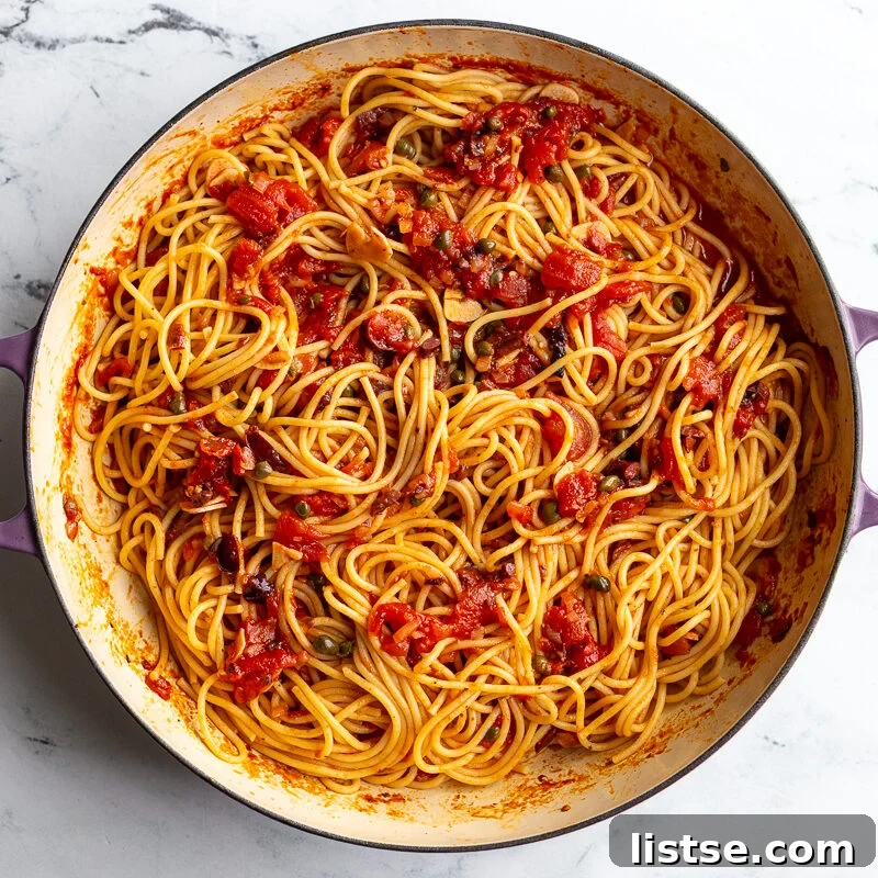 Classic Pasta Puttanesca Recipe with Anchovies and Olives 9 Spaghetti puttanesca tossed together in a skillet with sauce, olives, and capers.
