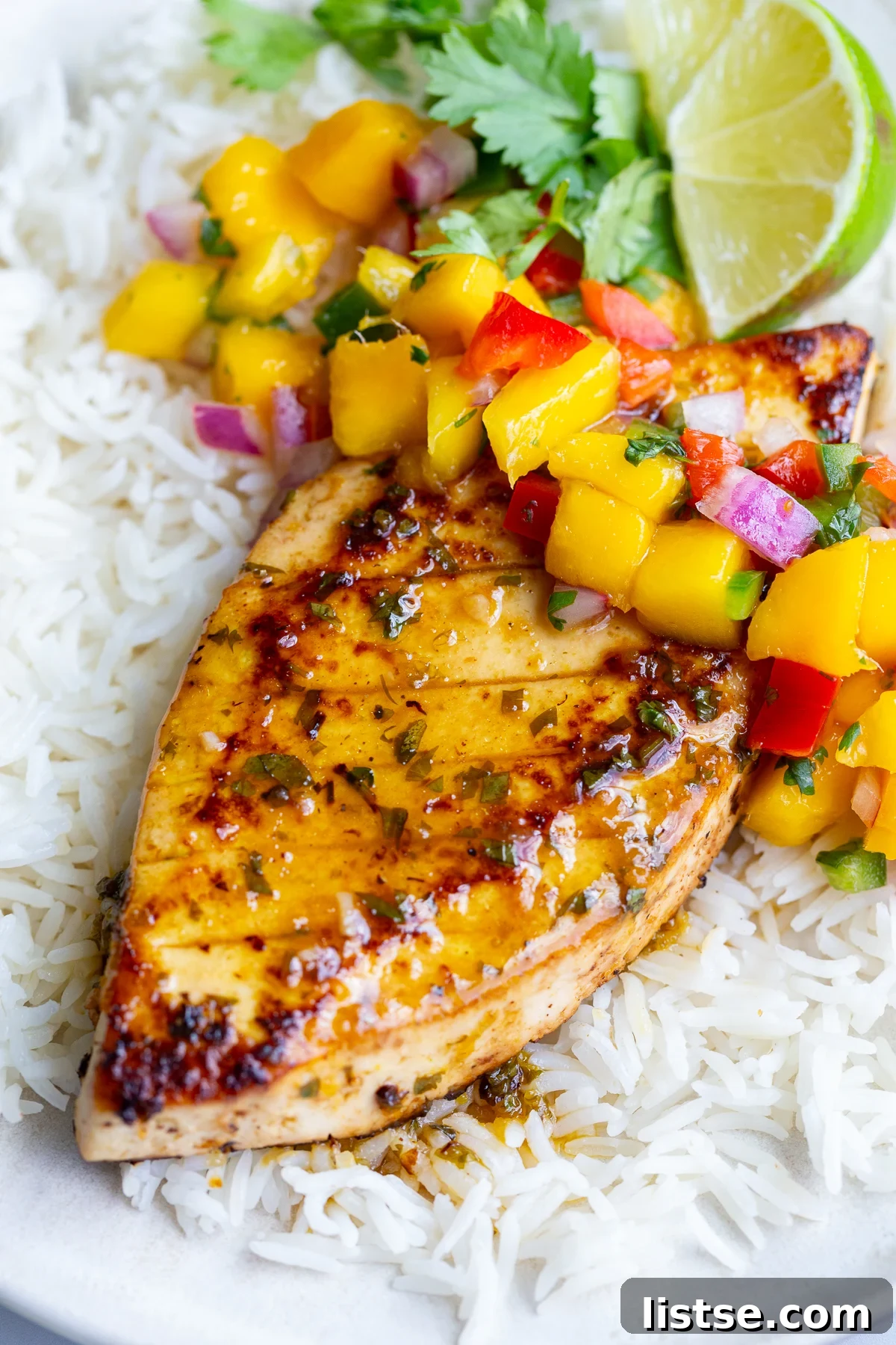 Cilantro-Lime Tofu with Fresh Mango Salsa 5 cilantro lime tofu that looks like grilled chicken with a mango salsa on top. all on a bed of rice
