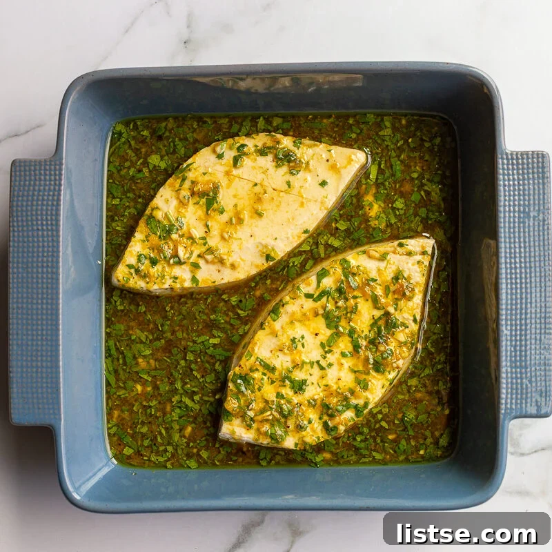 Cilantro-Lime Tofu with Fresh Mango Salsa 6 Two triangular slices of tofu marinating in a blue baking dish in a cilantro, lime, and garlic marinade.