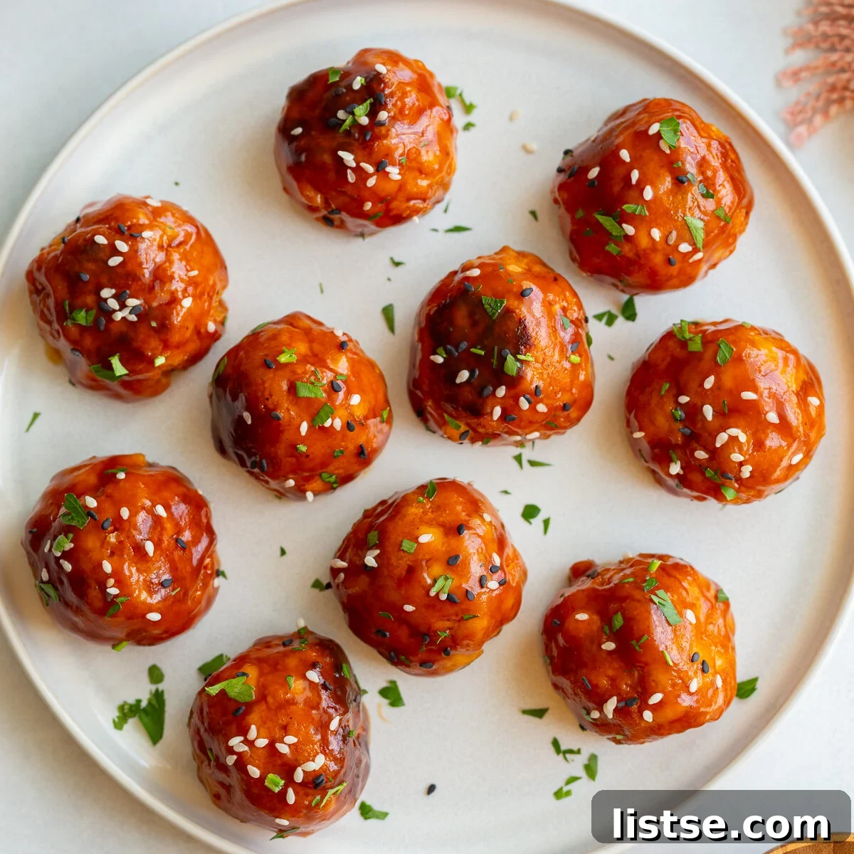 Crispy Vegan Tofu Meatballs: High-Protein Recipe 11 tofu meatballs covered in a sticky sauce and sesame seeds