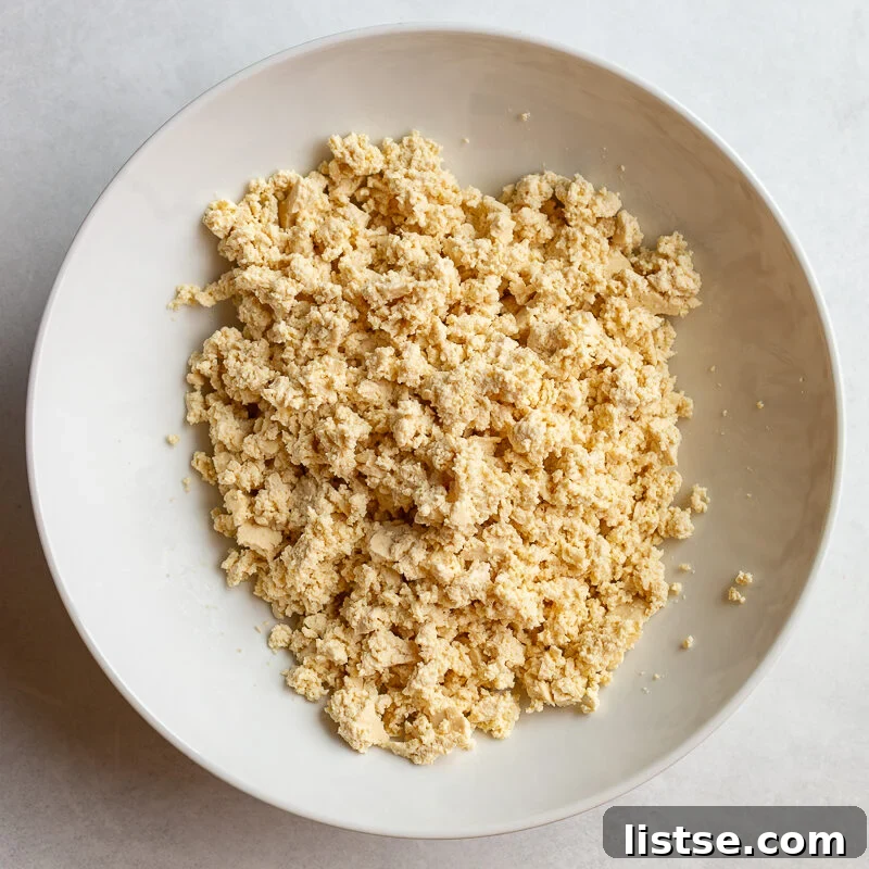 Crispy Vegan Tofu Meatballs: High-Protein Recipe 6 Crumbled tofu in a white bowl before being mixed with seasonings.