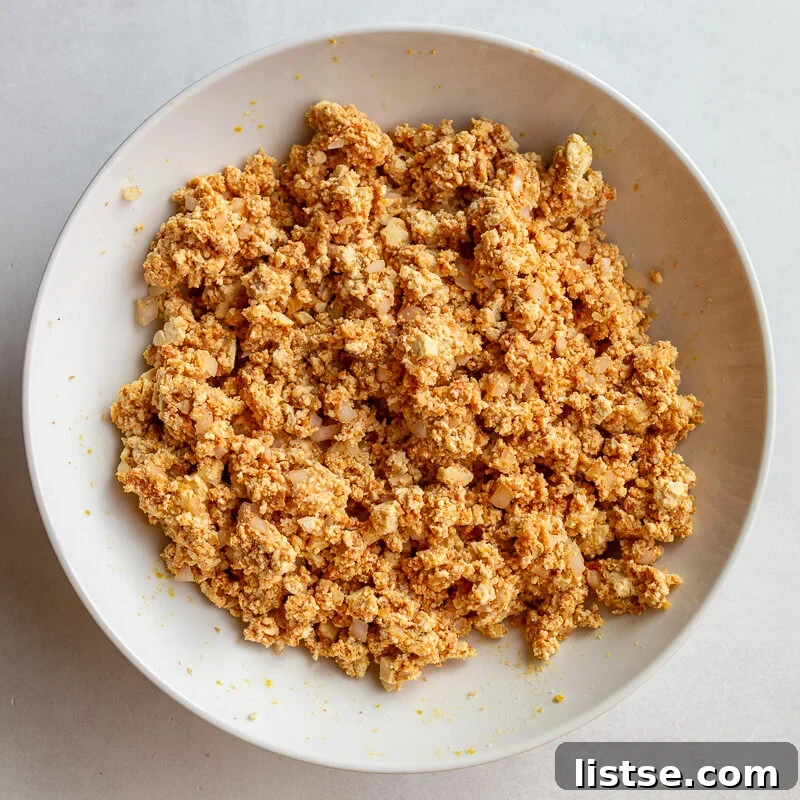Crispy Vegan Tofu Meatballs: High-Protein Recipe 7 Tofu meatball mixture combined with onion, tomato paste, and seasonings in a bowl.