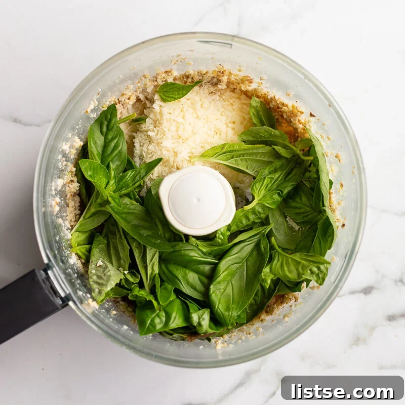 Homemade Walnut Pesto Recipe 7 Fresh basil leaves and grated parmesan added to the food processor on top of the pulsed walnut mixture
