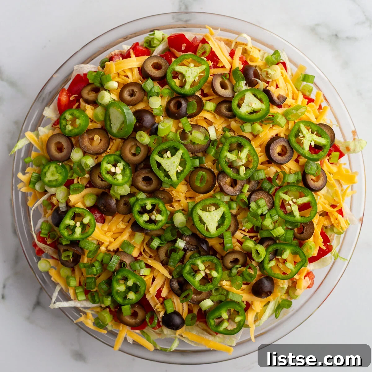 Cream Cheese Taco Dip Recipe for Parties 9 taco dip with cream cheese that's layered like a 7 layer dip with beans, cream cheese, lettuce, cheese, jalapeno, olives, and tomato