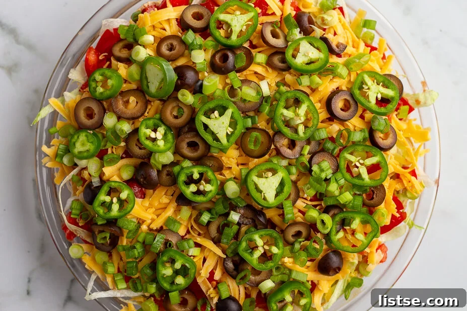 Cream Cheese Taco Dip Recipe for Parties 10 taco dip with cream cheese that's layered like a 7 layer dip with beans, cream cheese, lettuce, cheese, jalapeno, olives, and tomato